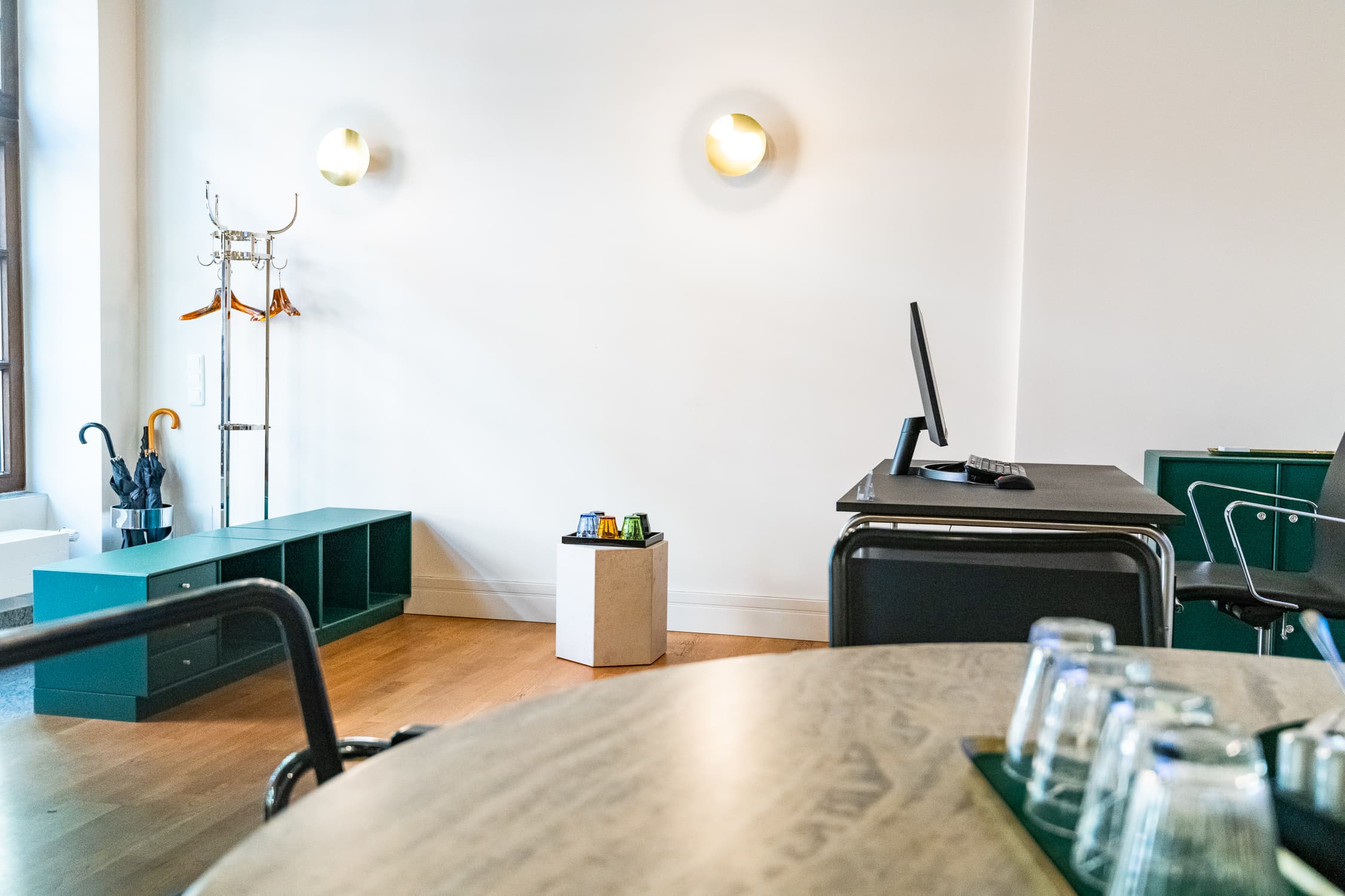 Empfangsraum mit Besprechungstisch und Garderobe im Büro Mandlstraße 22