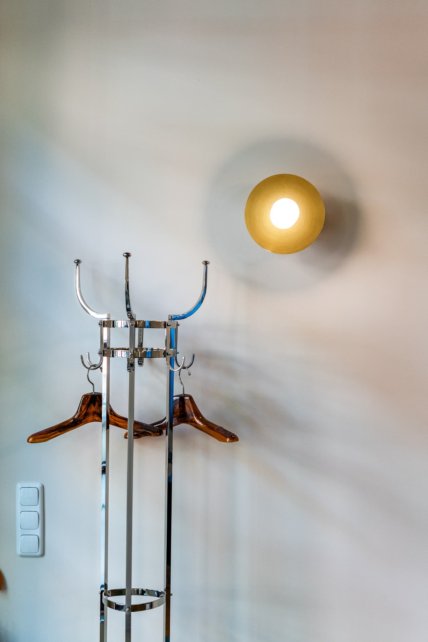 Verchromte Garderobe mit Messing-Wandleuchte im Büro